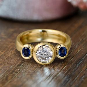 Bezel Round & Oval Cut White & Blue Sapphire Three Stone Engagement Ring