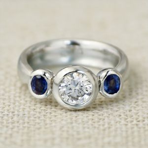 Bezel Round & Oval Cut White & Blue Sapphire Three Stone Engagement Ring