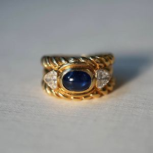 Golden Three Stone Oval Cabochon & Triangle Cut Blue & White Sapphire Engagement Ring